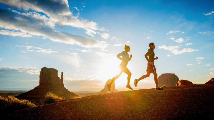 man and woman running with sports headphones
